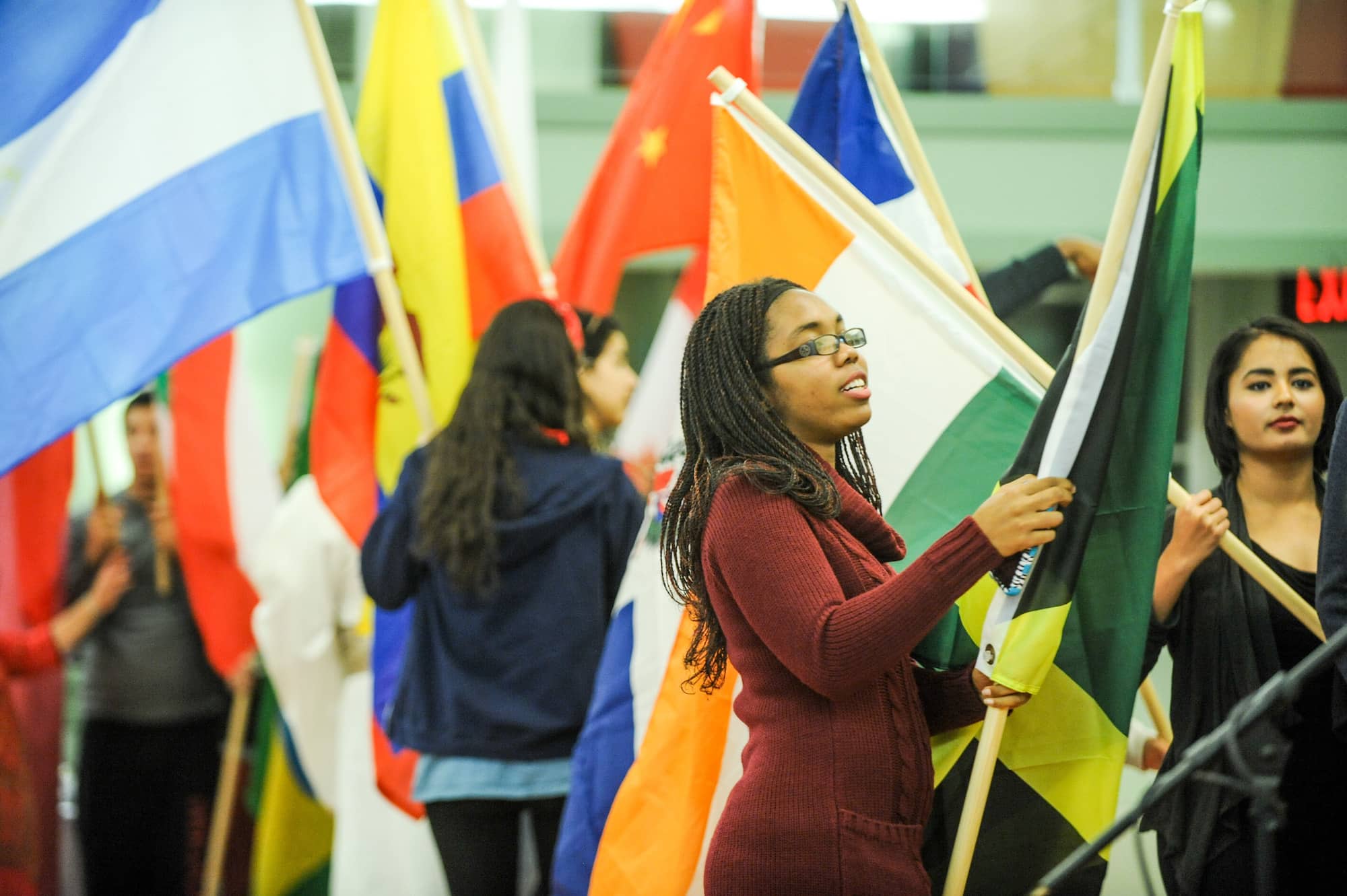 Students carrying flags from different countries