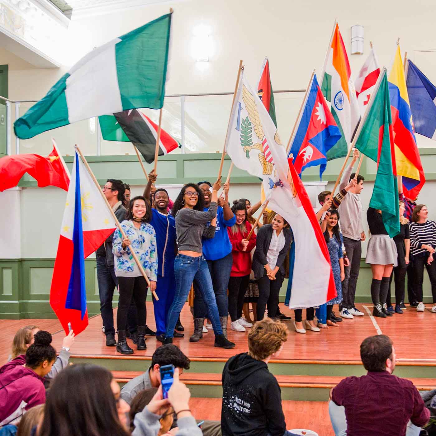 Students on stage with international flags