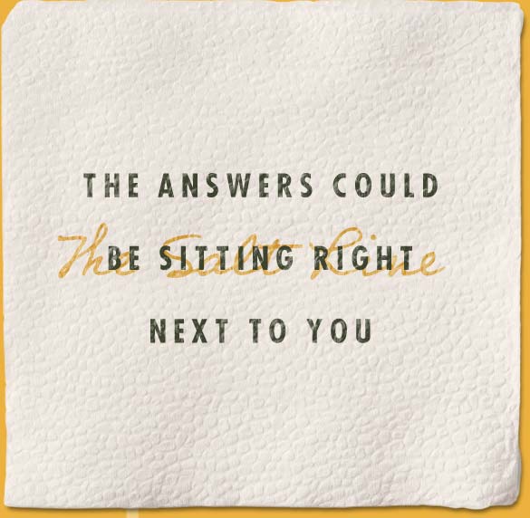 A napkin with "The answer could be sitting right next to you" on it