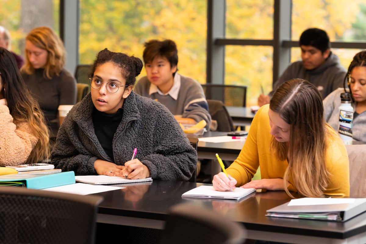 A group of people sitting at desks in a classroom.