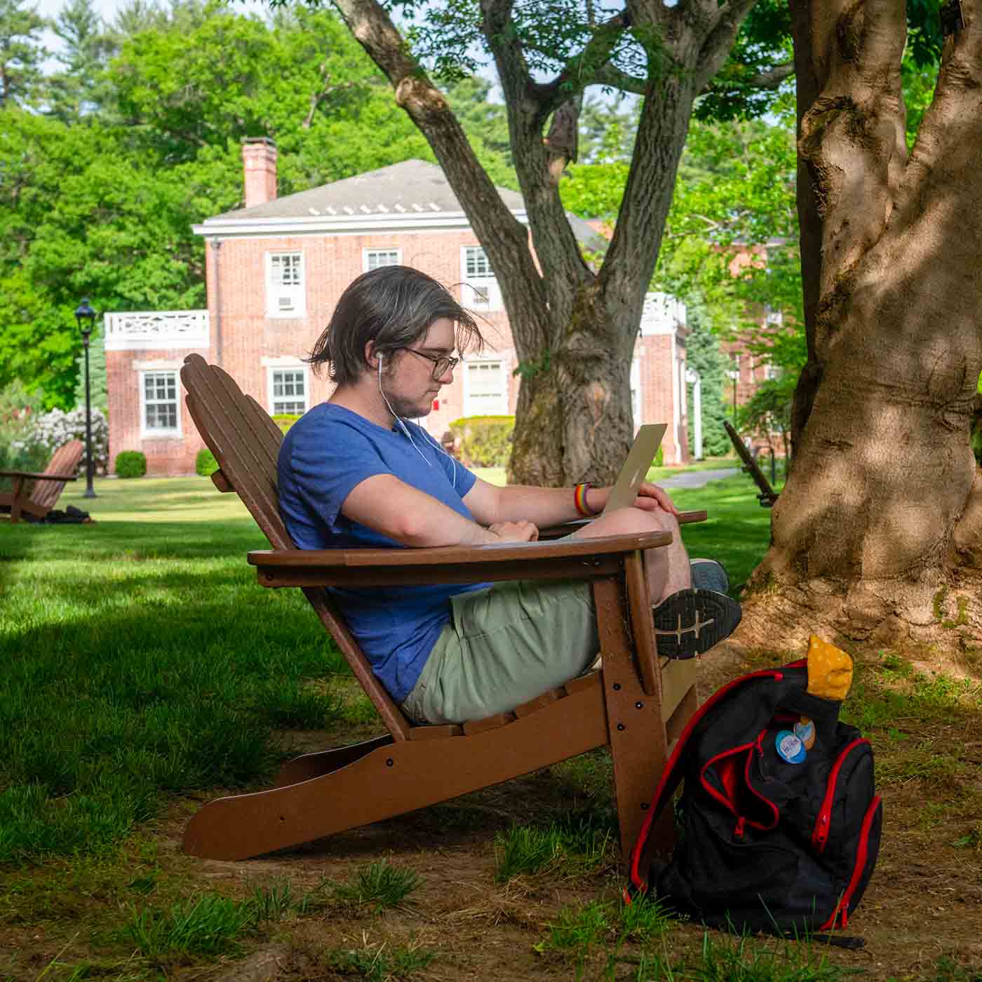 Two people sitting at the table in the Bridge for Laboratory Sciences seating conversing in front of a book and laptop