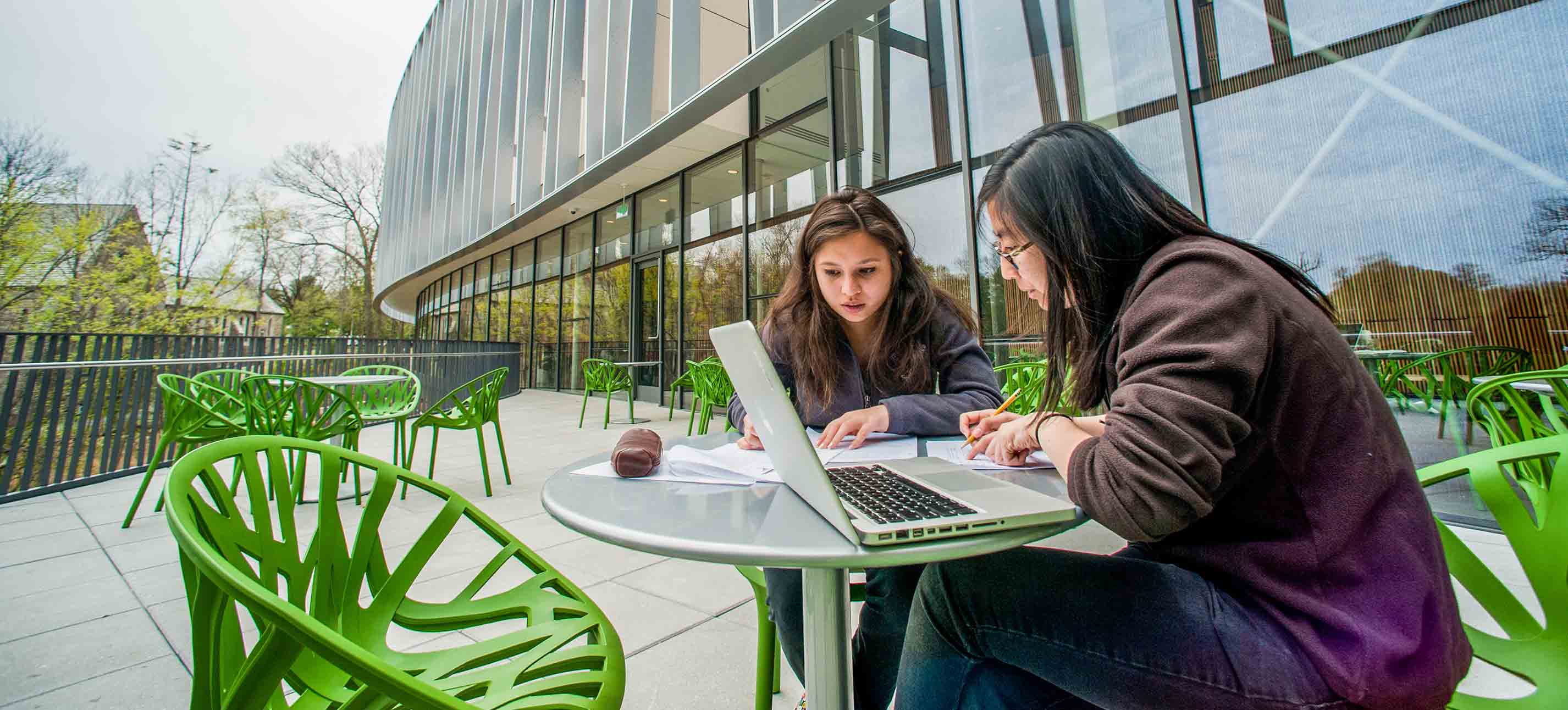 Students sitting on the veranda outside of the Bridge for Laboratory Sciences building studying.