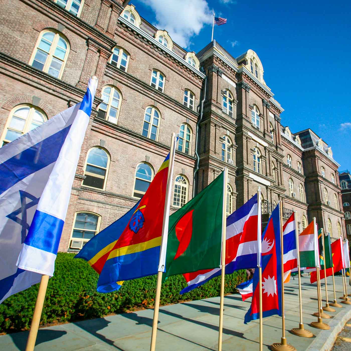 A row of brightly colored international flags in front of Main Building