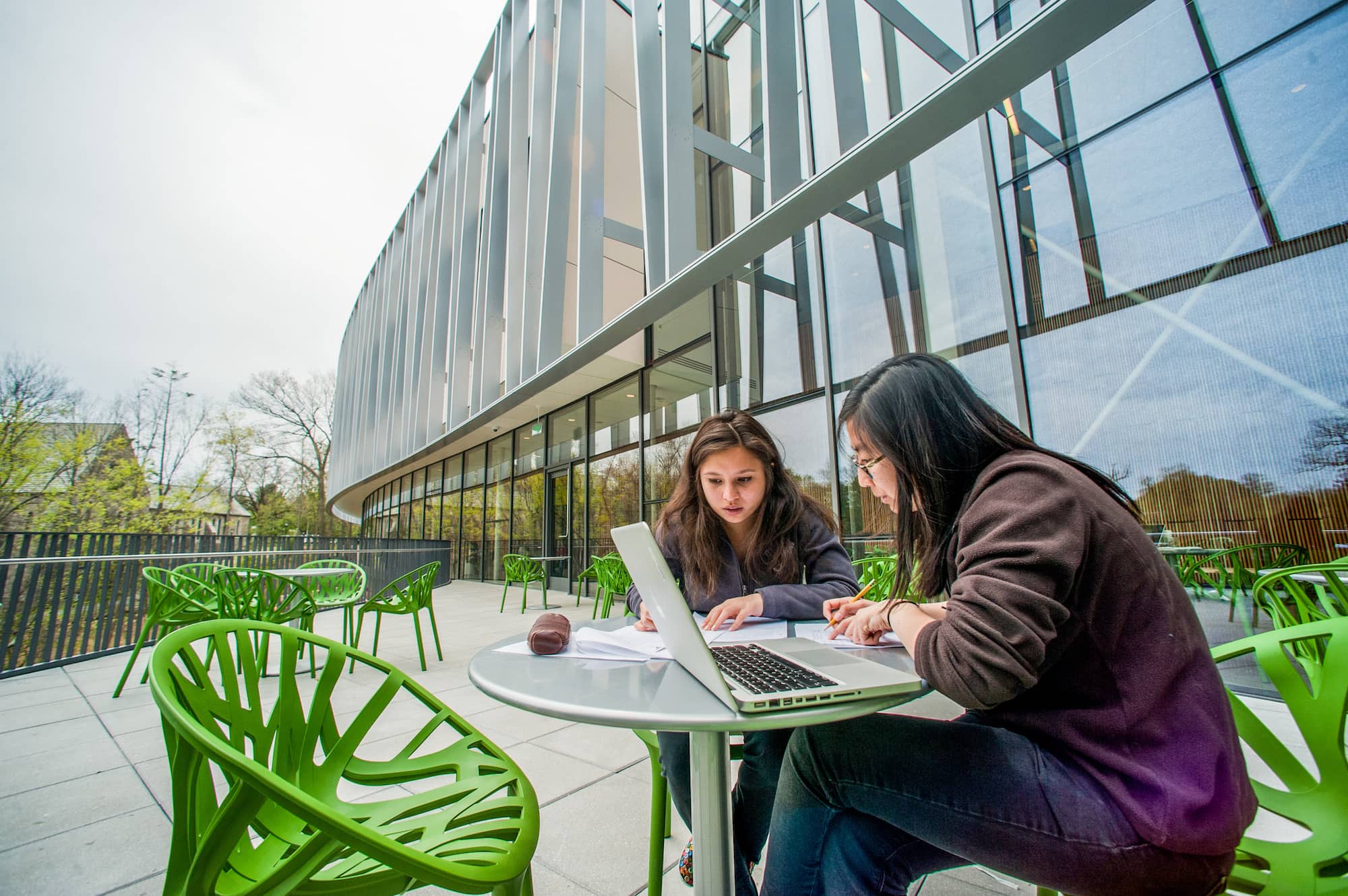 Students sitting on the veranda outside of the Bridge for Laboratory Sciences building studying.