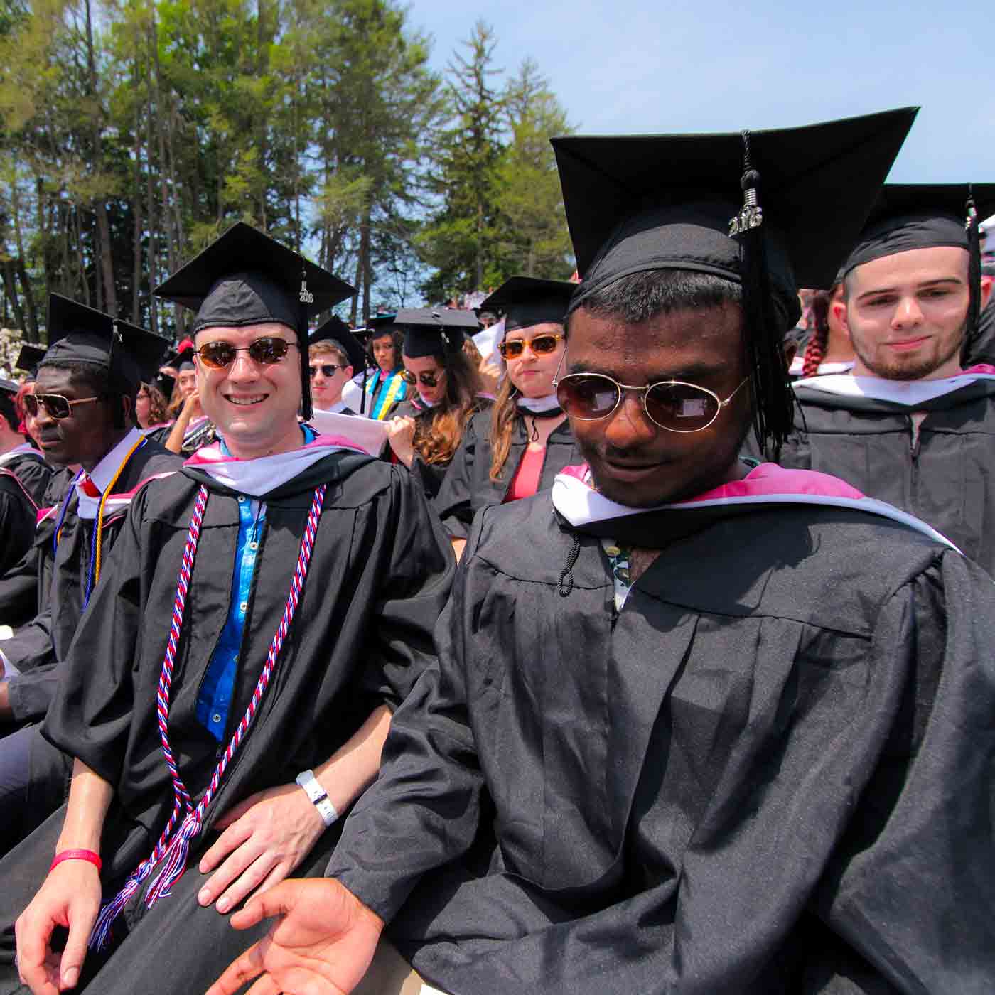 Students sitting outside ready for graduation ceremonies to start