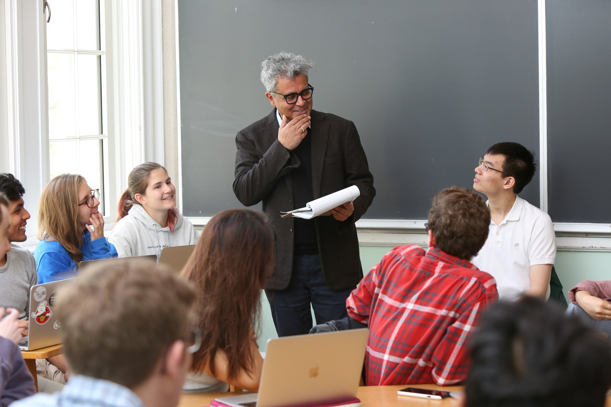 A professor stands among students during a class