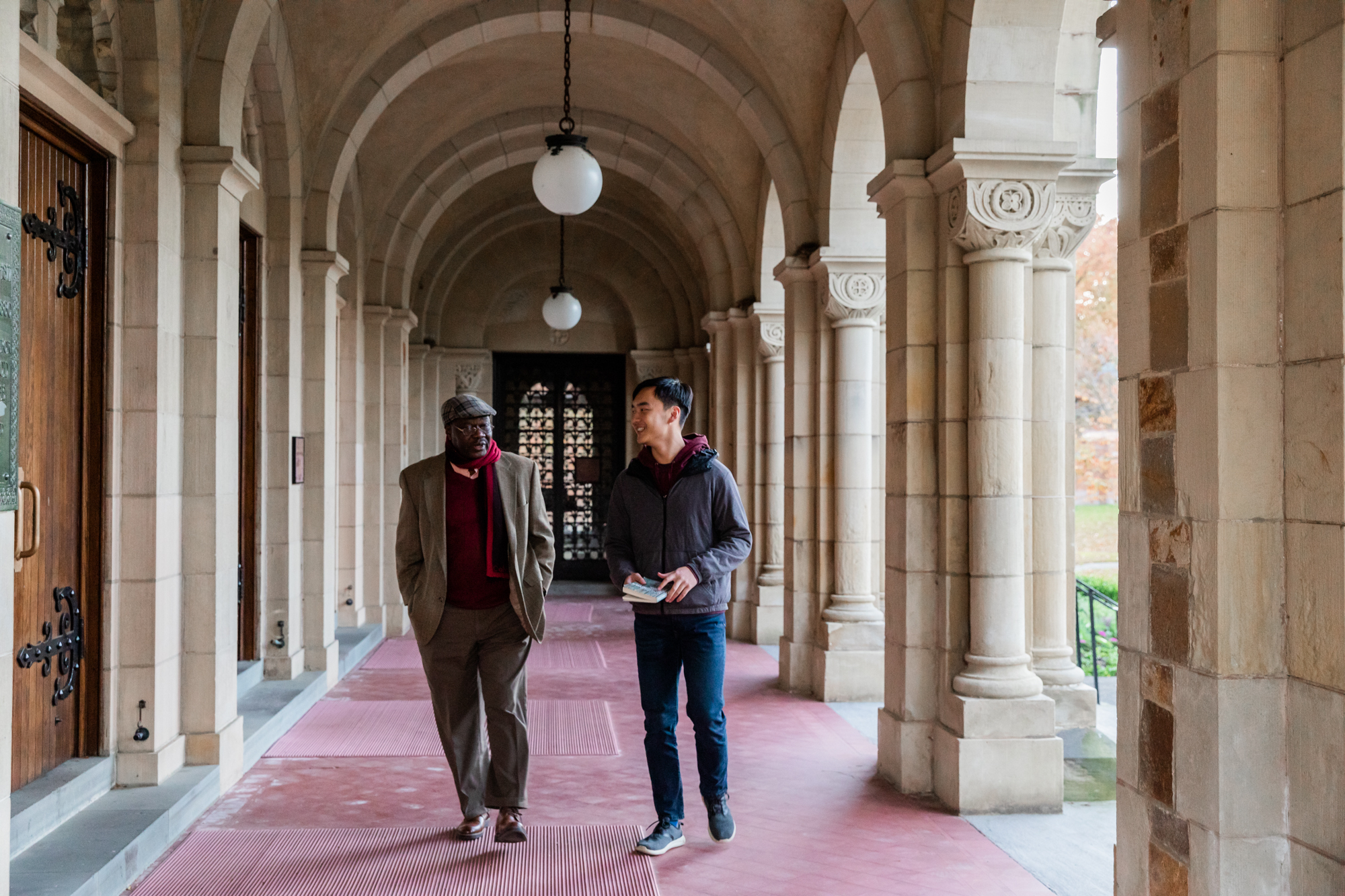 Two people walking under the arched entrance to the Vassar Chapel