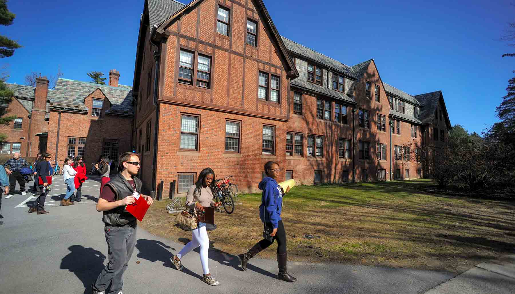 A photo of a group of people walking out of and around Cushing House