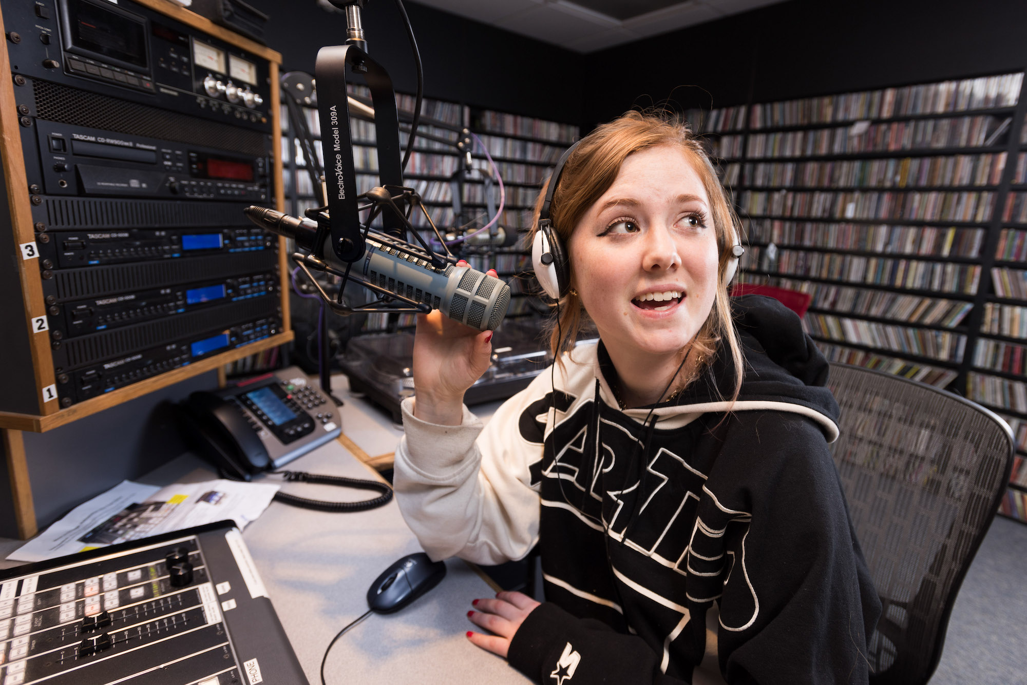 Student on air in front of  the microphone at Vassar’s radio station WVKR