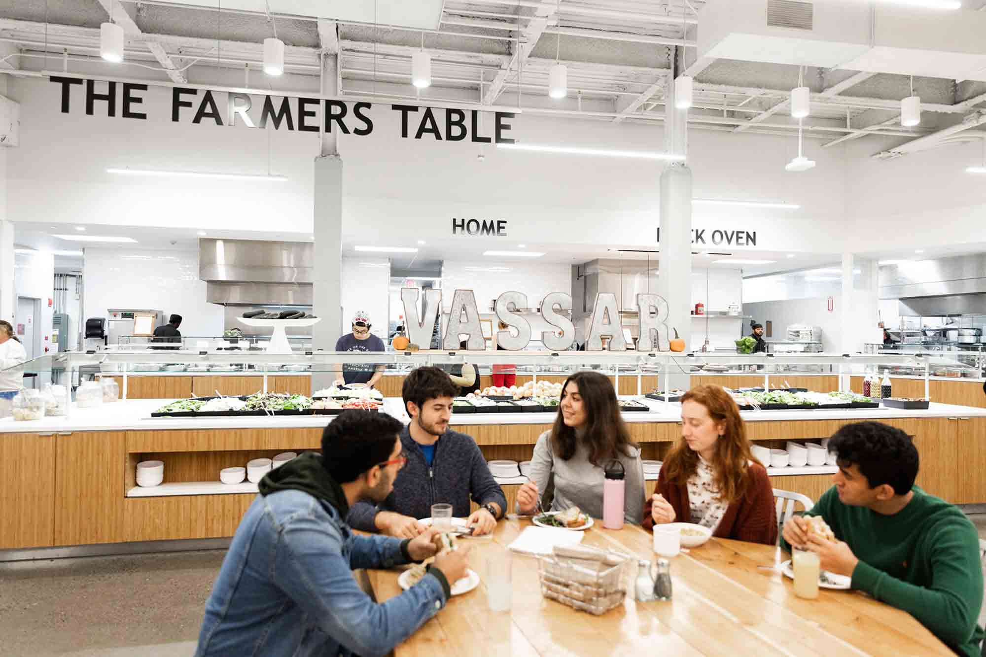 Students sit at a table in the large common area of Gordon Commons