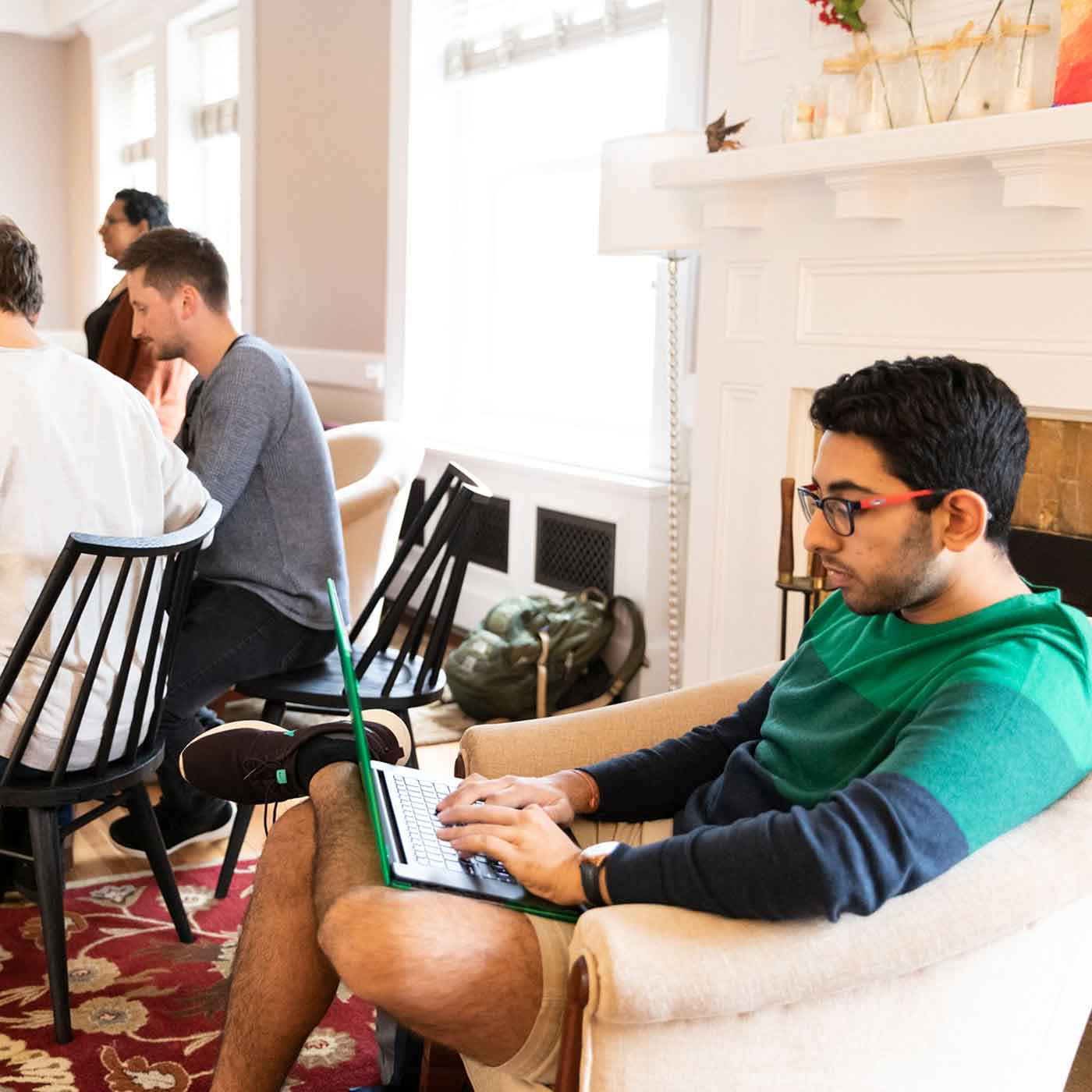 A student sits in a large room working at a laptop