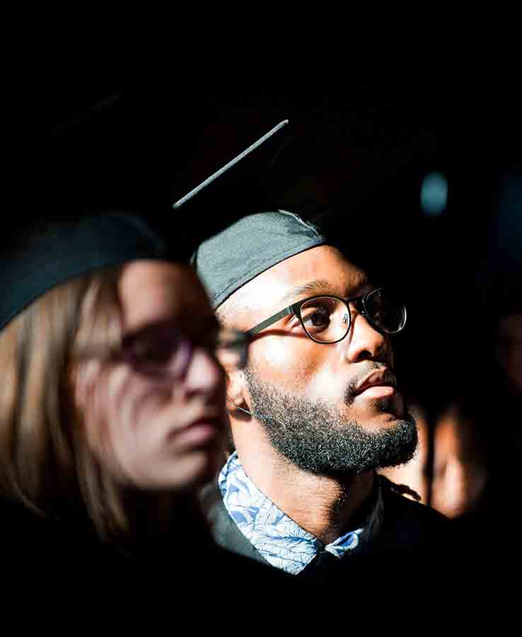 Graduate in audience with dramatic lighting