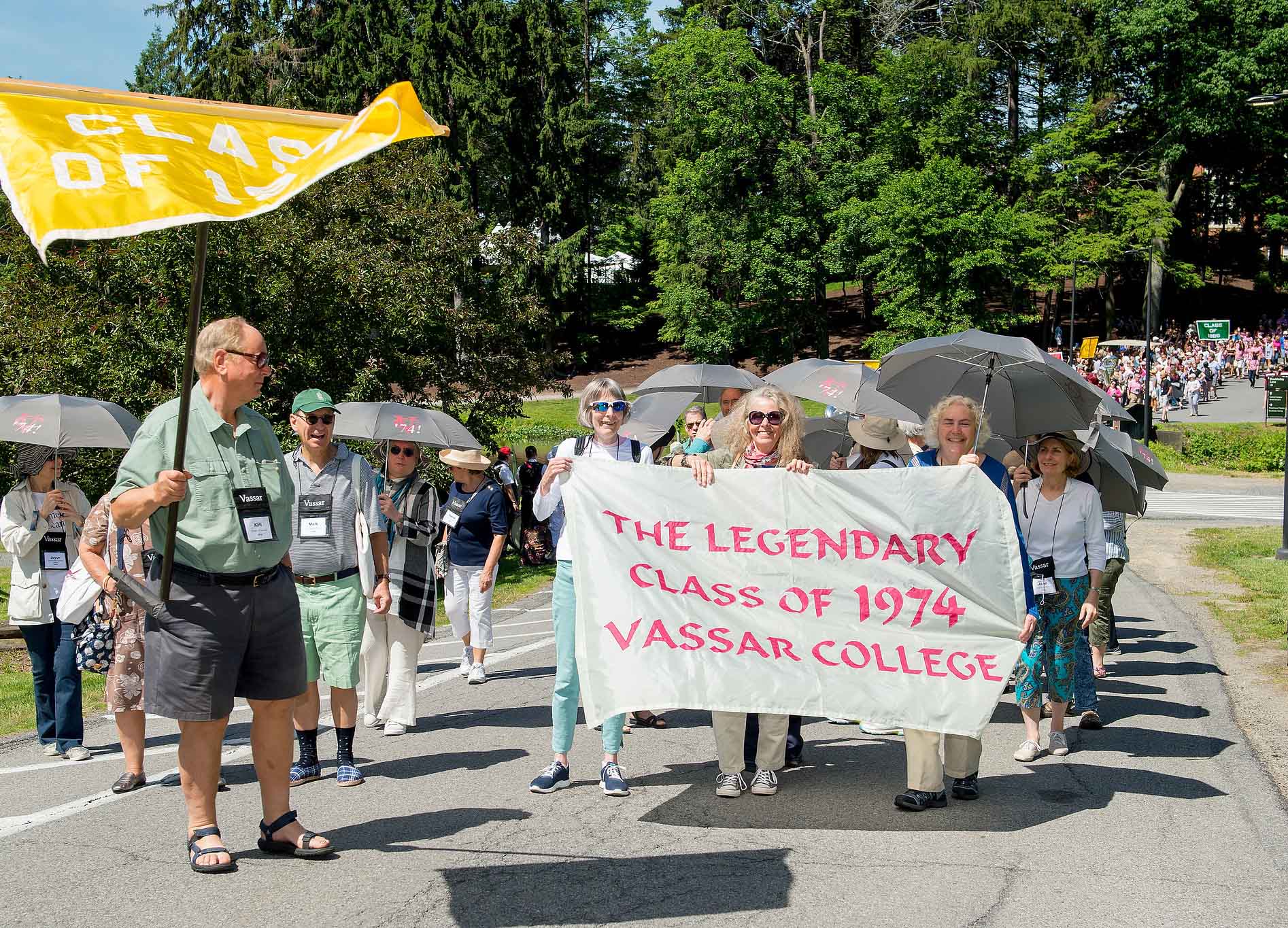 People walking in a group, with some people holding a banner reading The Legendary Class of 1974