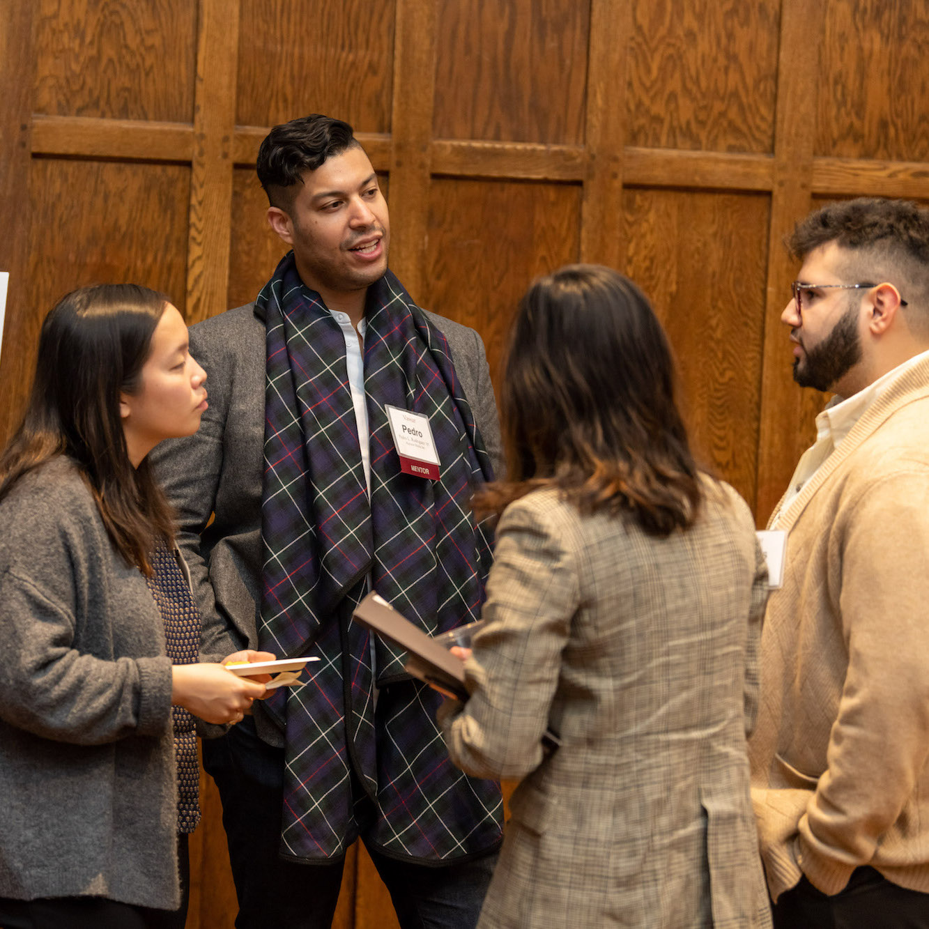 Four people, standing in a circle, speaking and gesturing to each other.