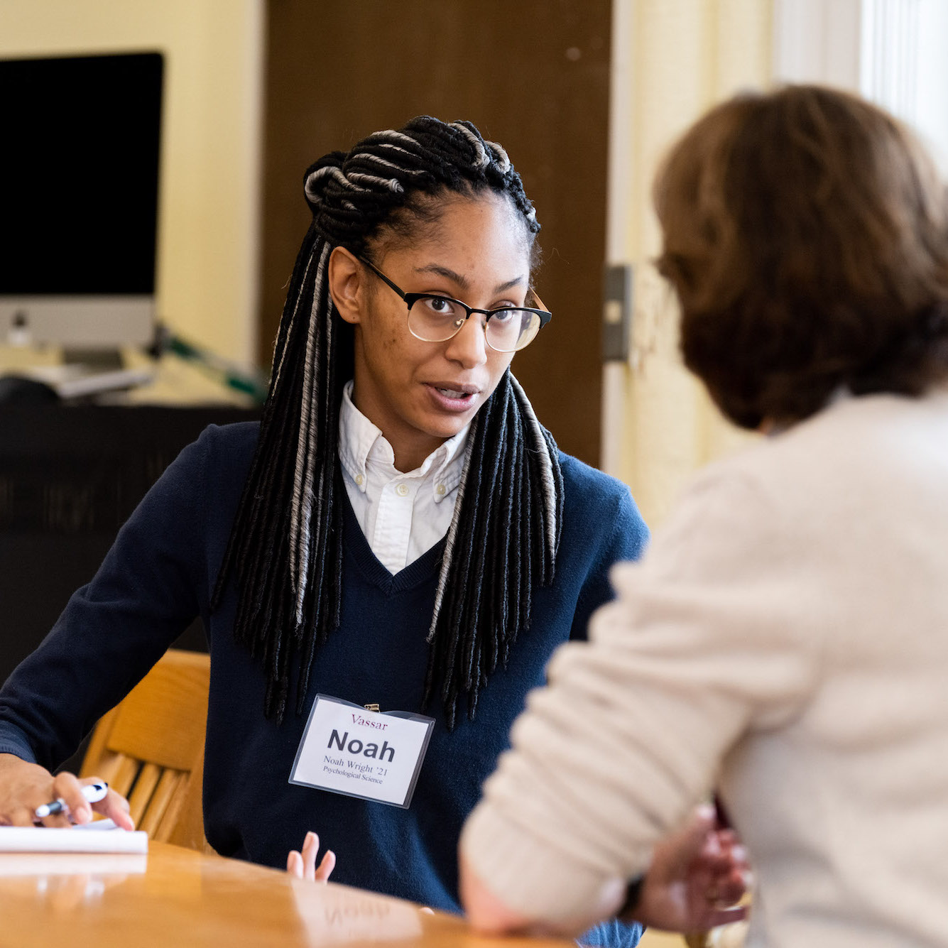 Person with nametag that reads, Noah, speaking to another person