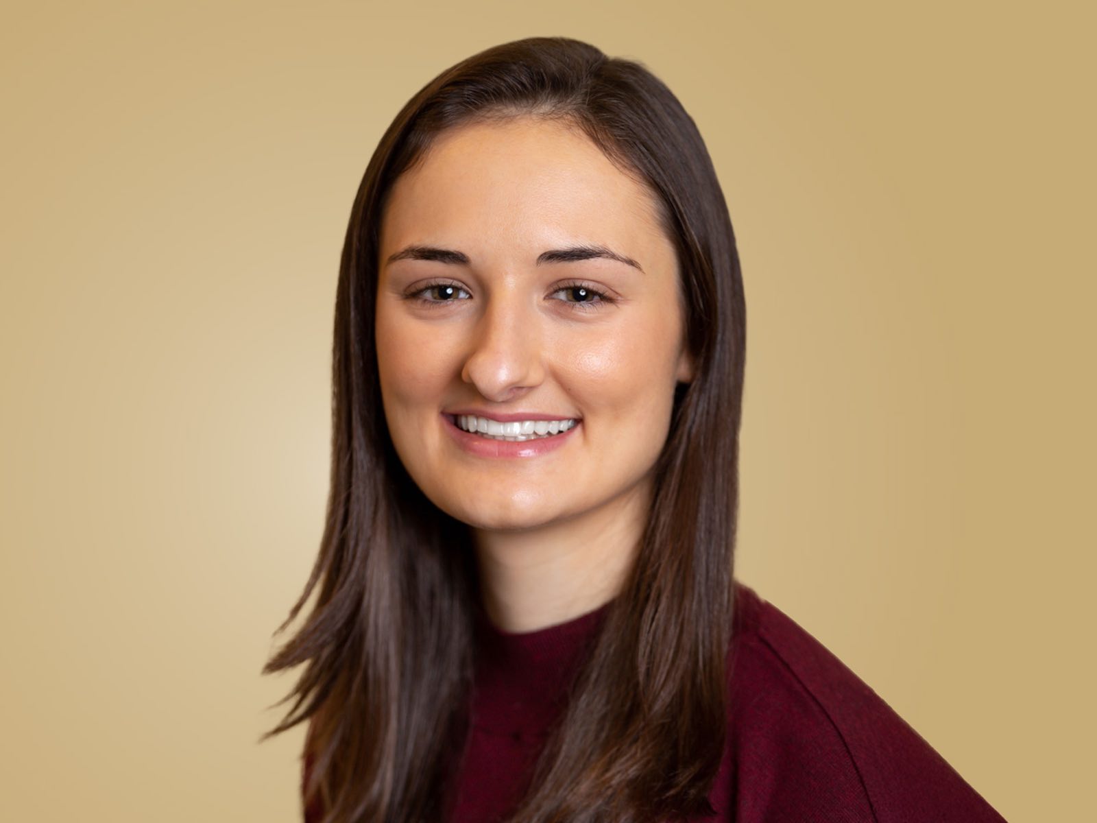 Headshot of Dr. Alexa Mousley ’20, a person with long dark hair and a maroon shirt.