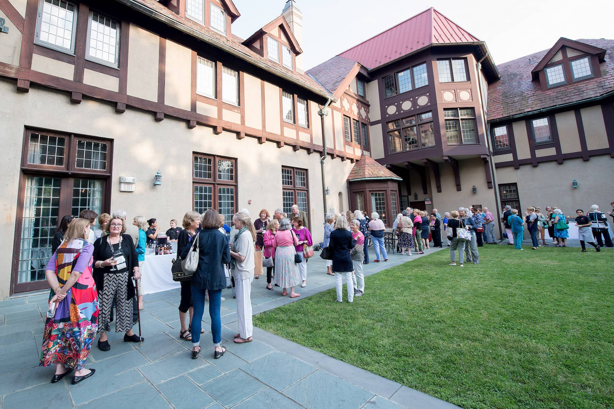 Gathering of people in the Alumnae House courtyard