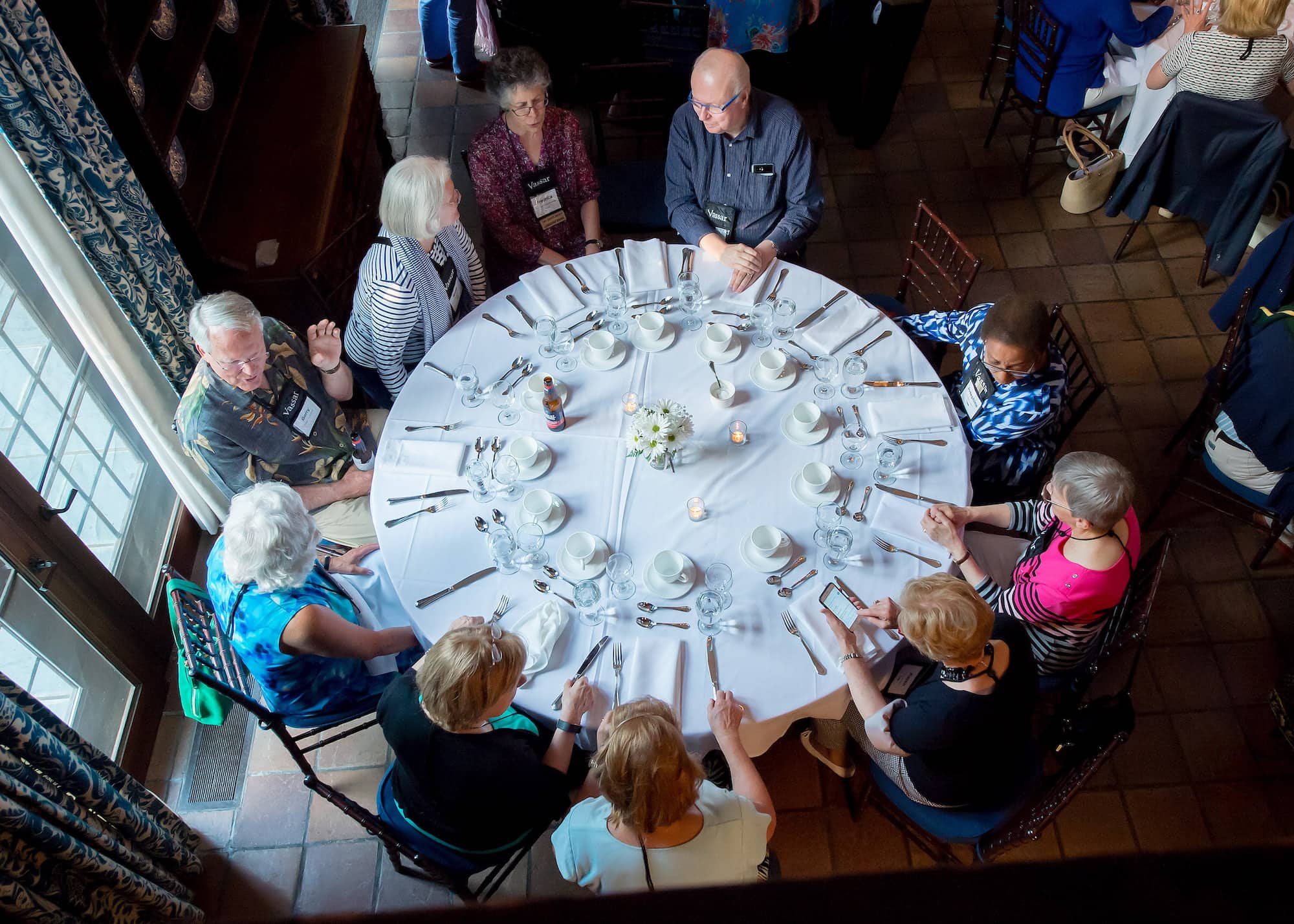 Overhead view of a set table and people seated around it