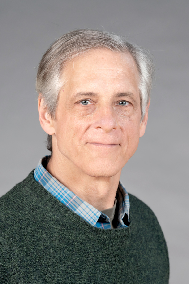 Luke Hunsberger wearing a green sweater over a blue plaid shirt.