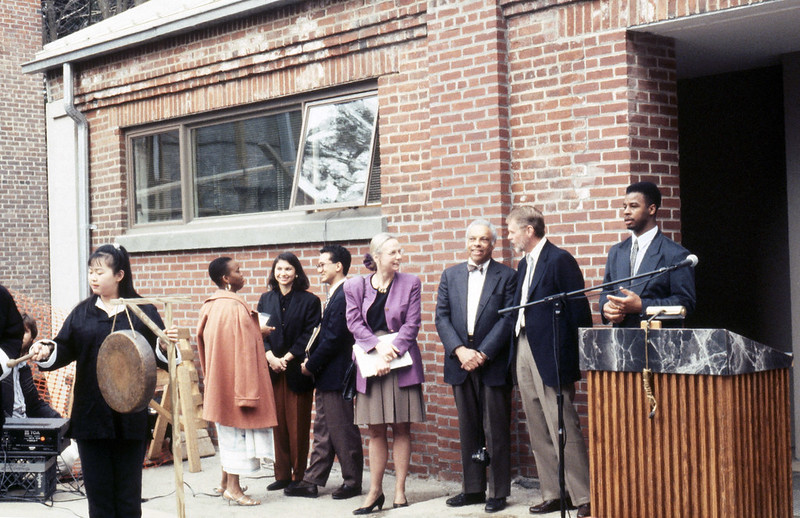 Photo from archives: opening of the ALANA Center. People standing near a podium.