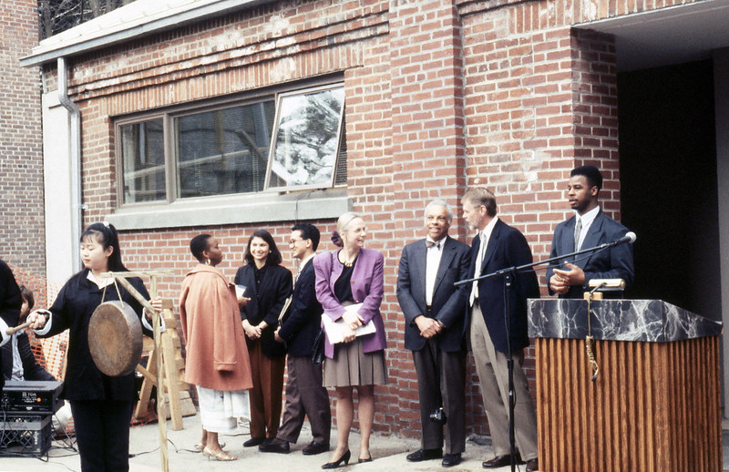 Photo from archives: opening of the ALANA Center. People standing near a podium.