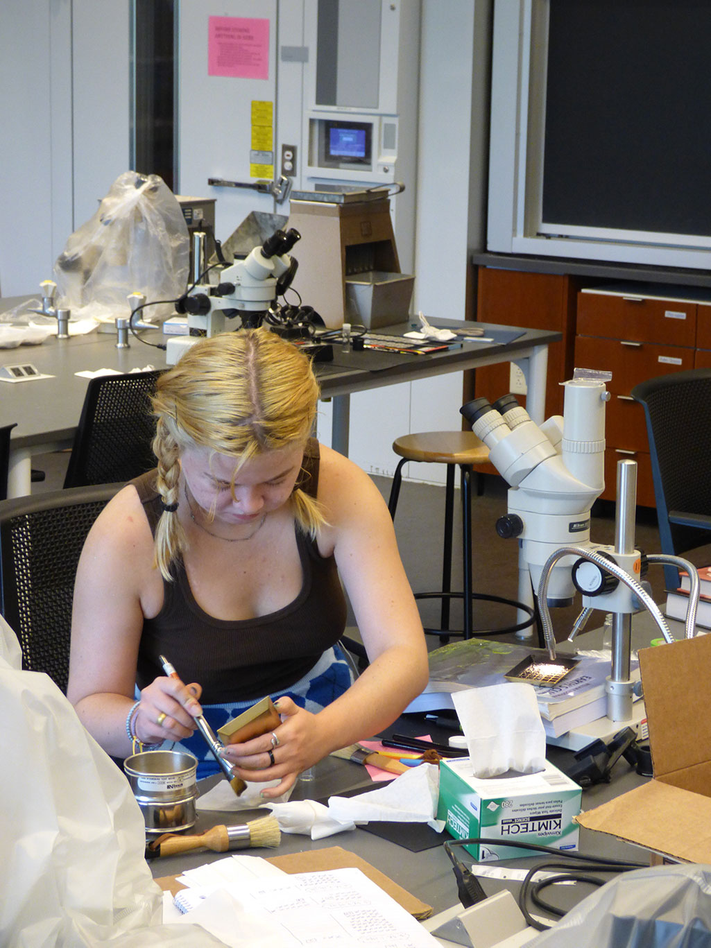 URSI student Ada King ‘23 prepares a fossil for viewing under the microscope.