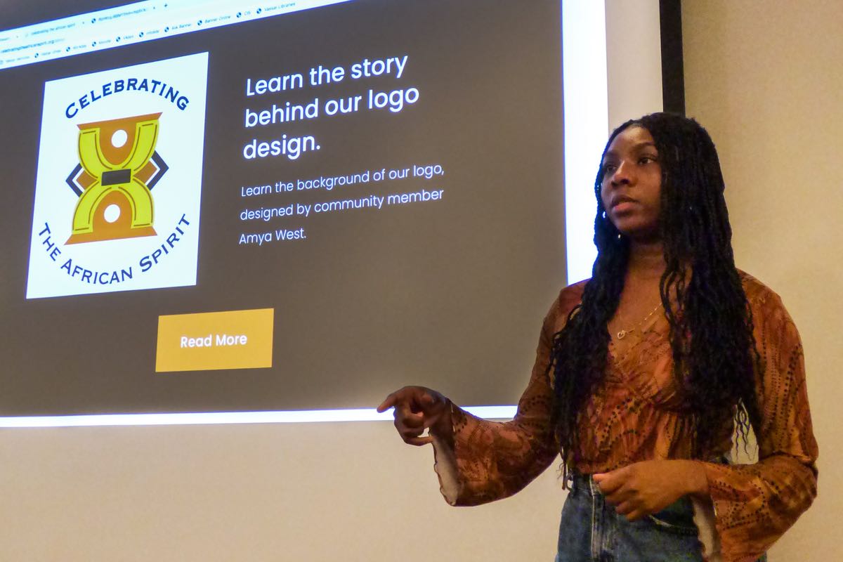 A girl speaks in front of a slide presentation.