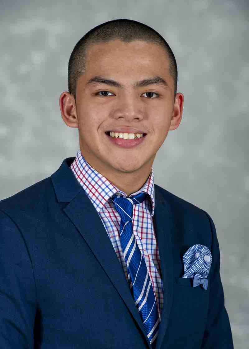 A formal portrait of a young man wearing a blue sport jacket.