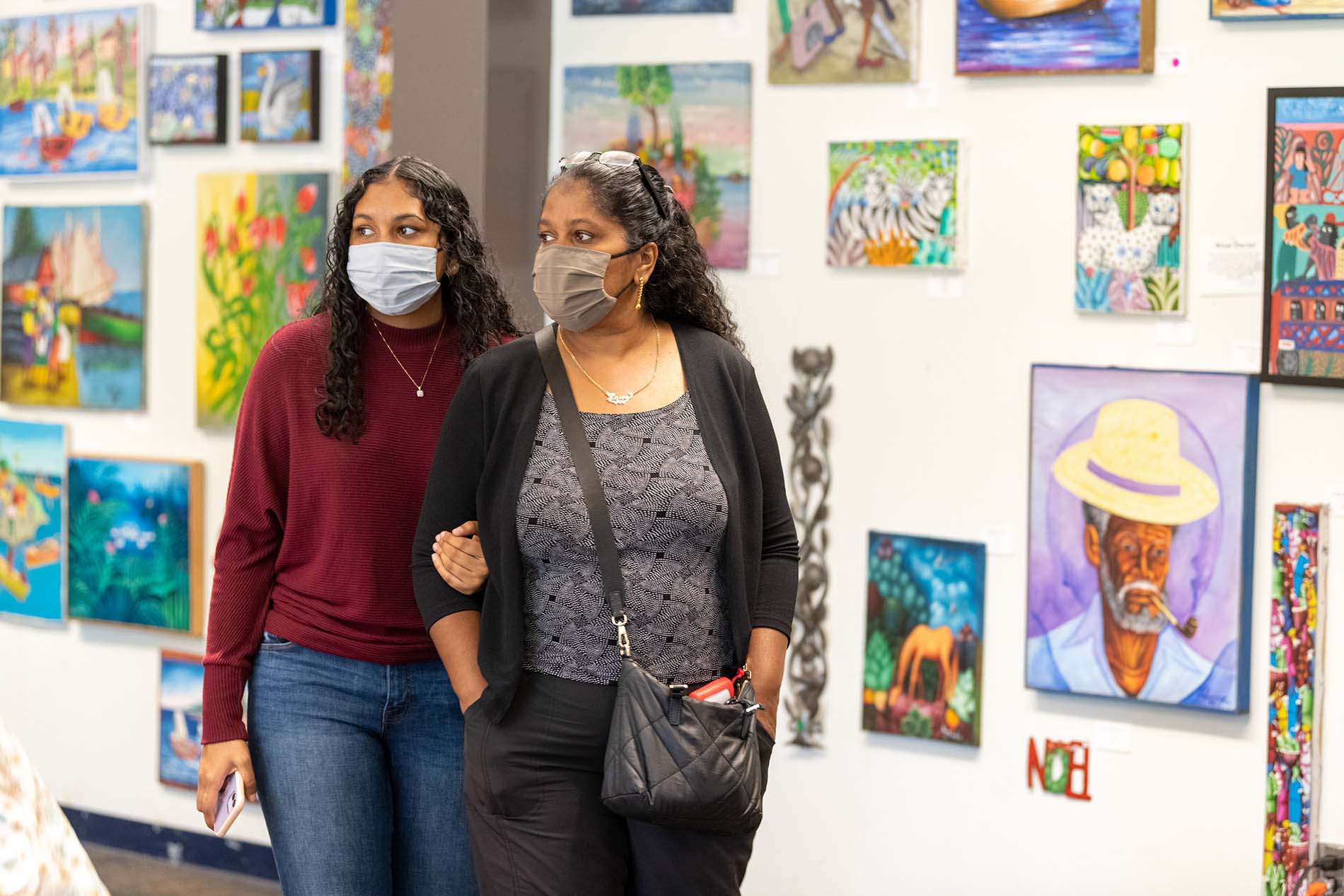 Families look over the art for sale at the Haiti auction