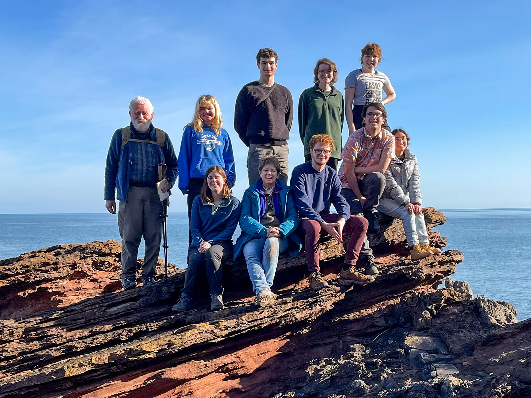 Standing on the birthplace of modern Geology, Siccar Point. Front: Lilly Tipton, Professor Jill Schneiderman, Thomas Friedlich. Rear: Professor of Earth Science Jeff Walker, Jeff Walker, Ada King, Will Riley, Carolyn Frost, Carter Mucha