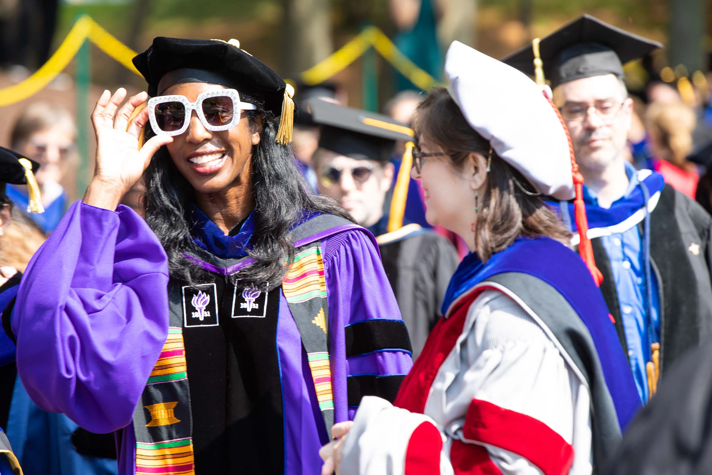 Faculty members, including Professor Mia Mask, left, file in for the ceremony. 