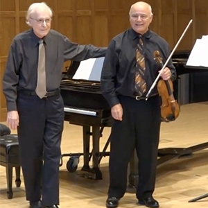 Pianist Richard Wilson and violinist Joseph Genualdi stand together onstage