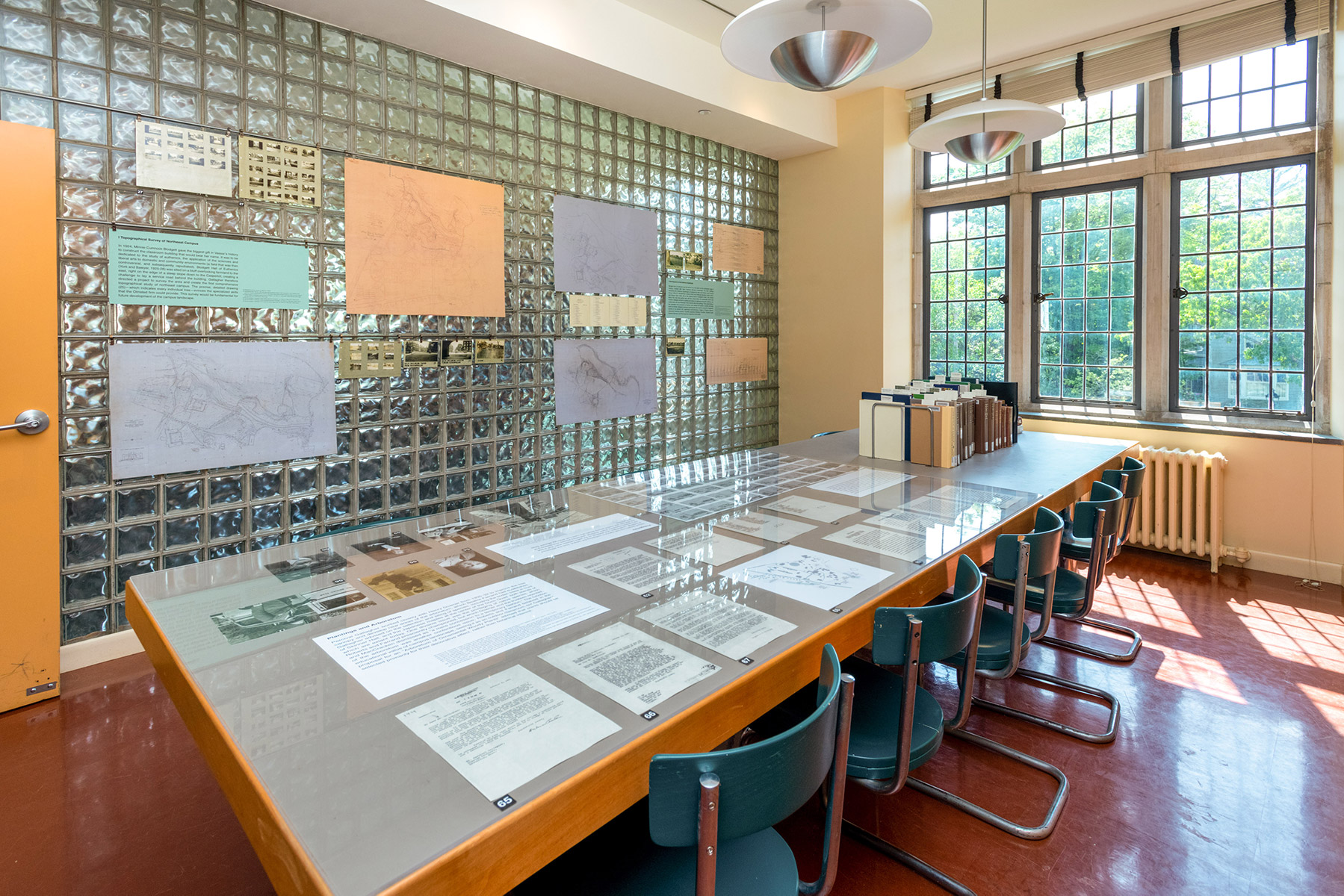 From the Main Room of the Art Library, the exhibition continues in reading room AL2, where the walls were originally designed with built-in hardware for hanging study images. The table is transformed into a vitrine, as well as housing select readings on the Olmsteds and American landscape architecture.