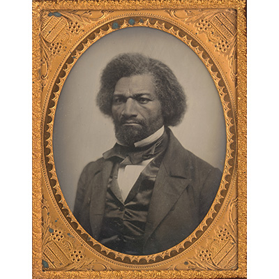 A black-and-white photo of abolitionist Frederick Douglass in an ornate gold frame