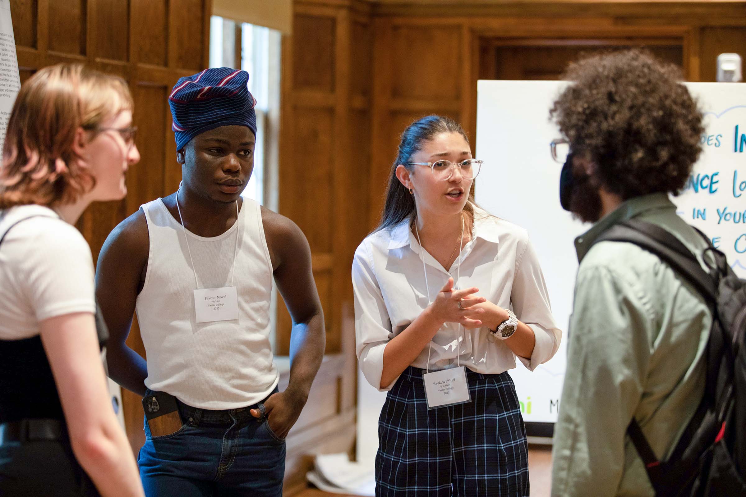 Vassar students (from left) Kali vom Eigen ’23, Favour Movel ’25 and Kayla Walthall ’23 share ideas with another student at the symposium.