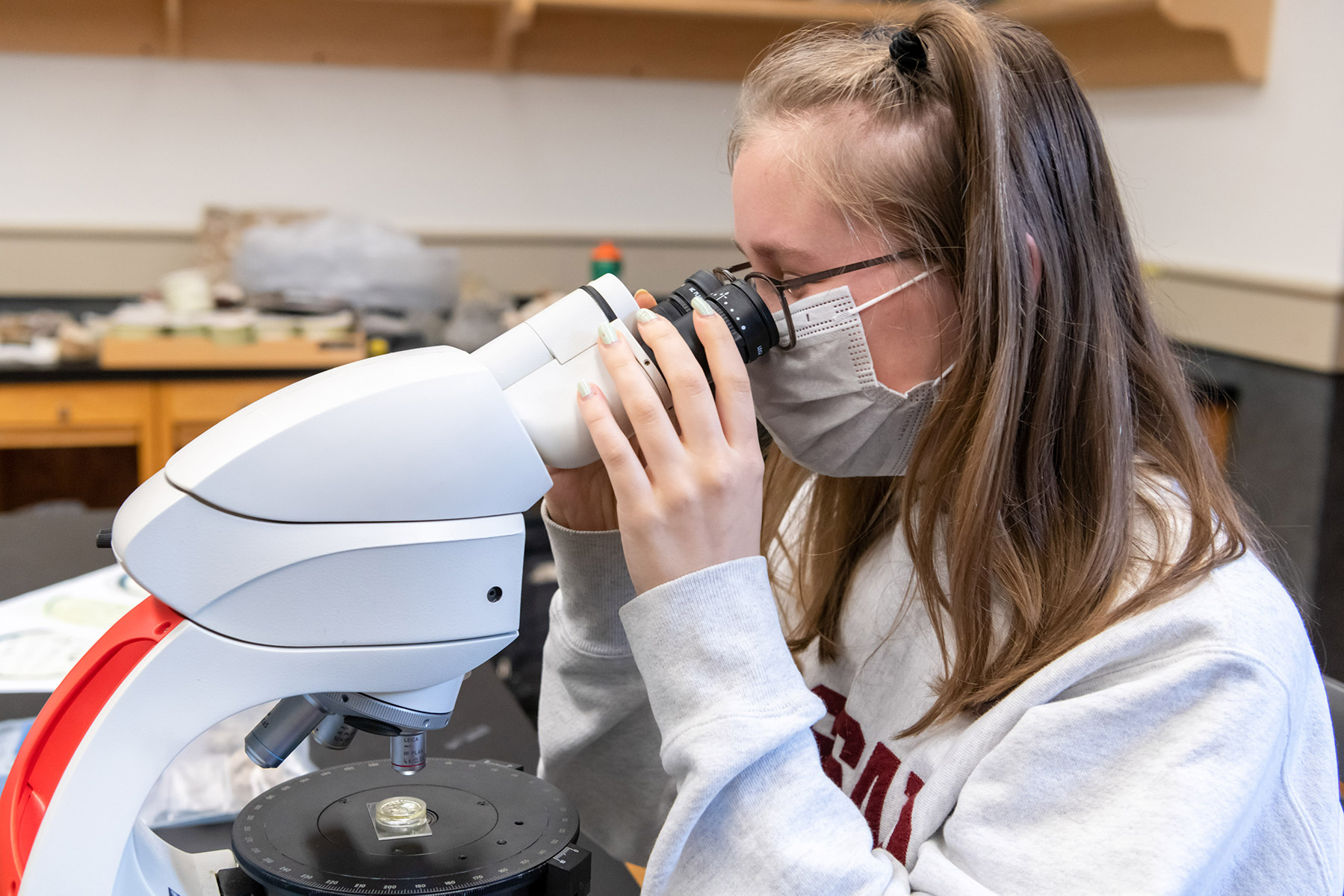Monika Sweeney ’24 examines a rock sample. “I was struck by how much information we can pull from a rock that can fit in the palm of my hand.”  