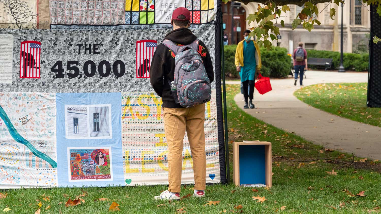 Person looking at a quilt displayed upright on Vassar campus