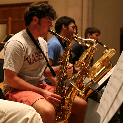 Three students playing saxophones.
