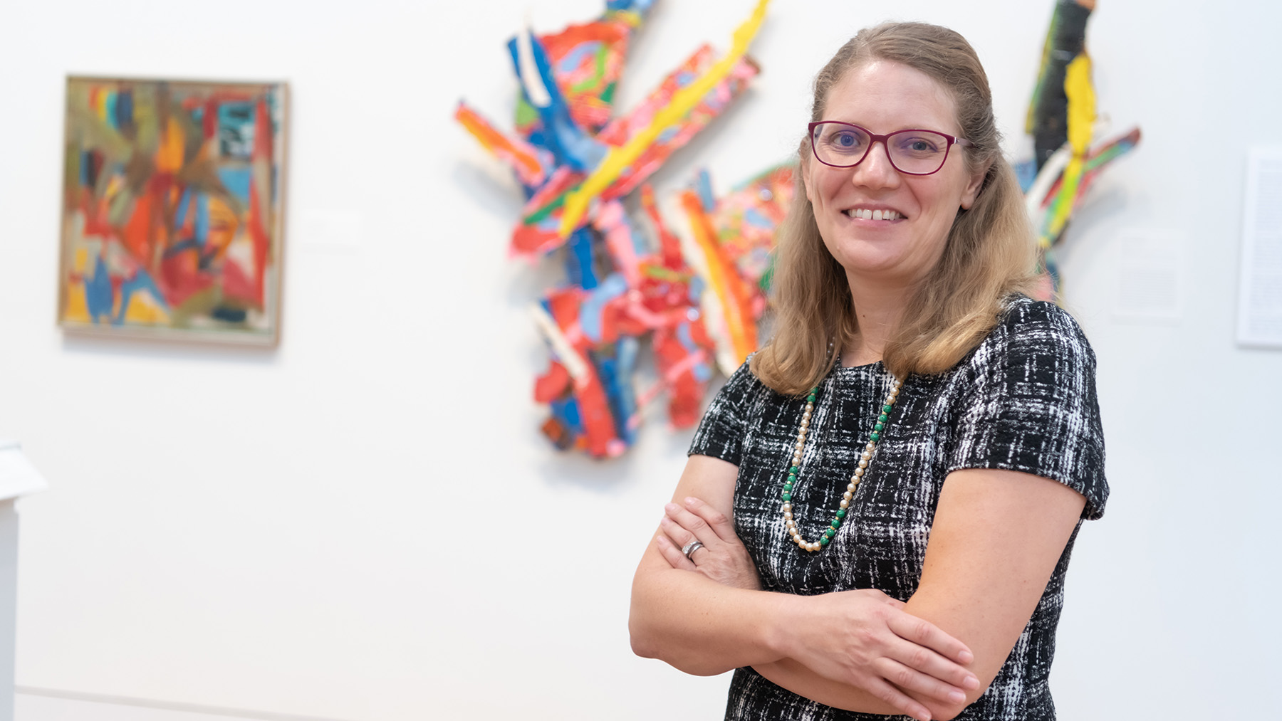 Amanda Potter standing in front of artwork at the Frances Lehman Loeb Art Center