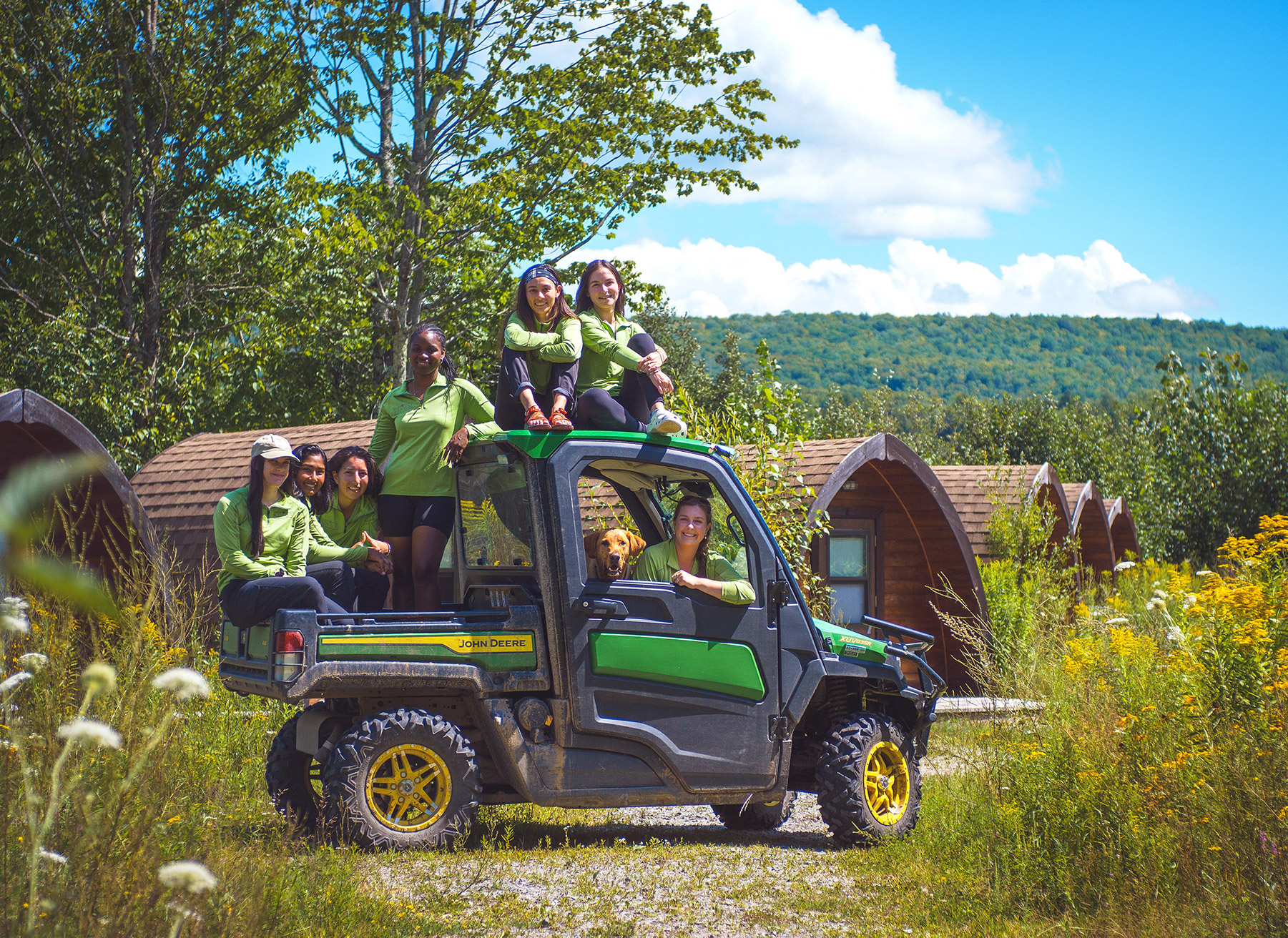 Group of students sitting on and in an off-road pickup truck