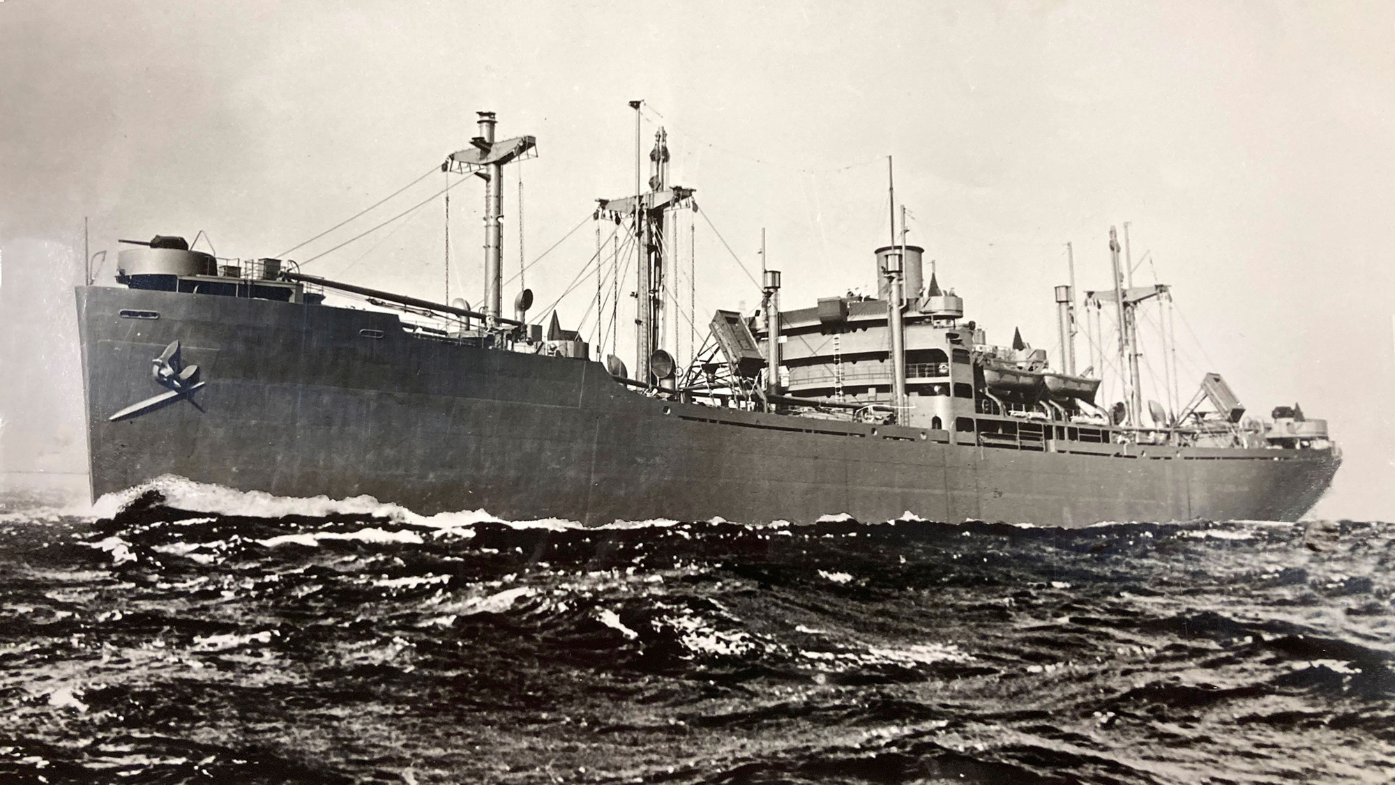 An old black and white ship at sea.