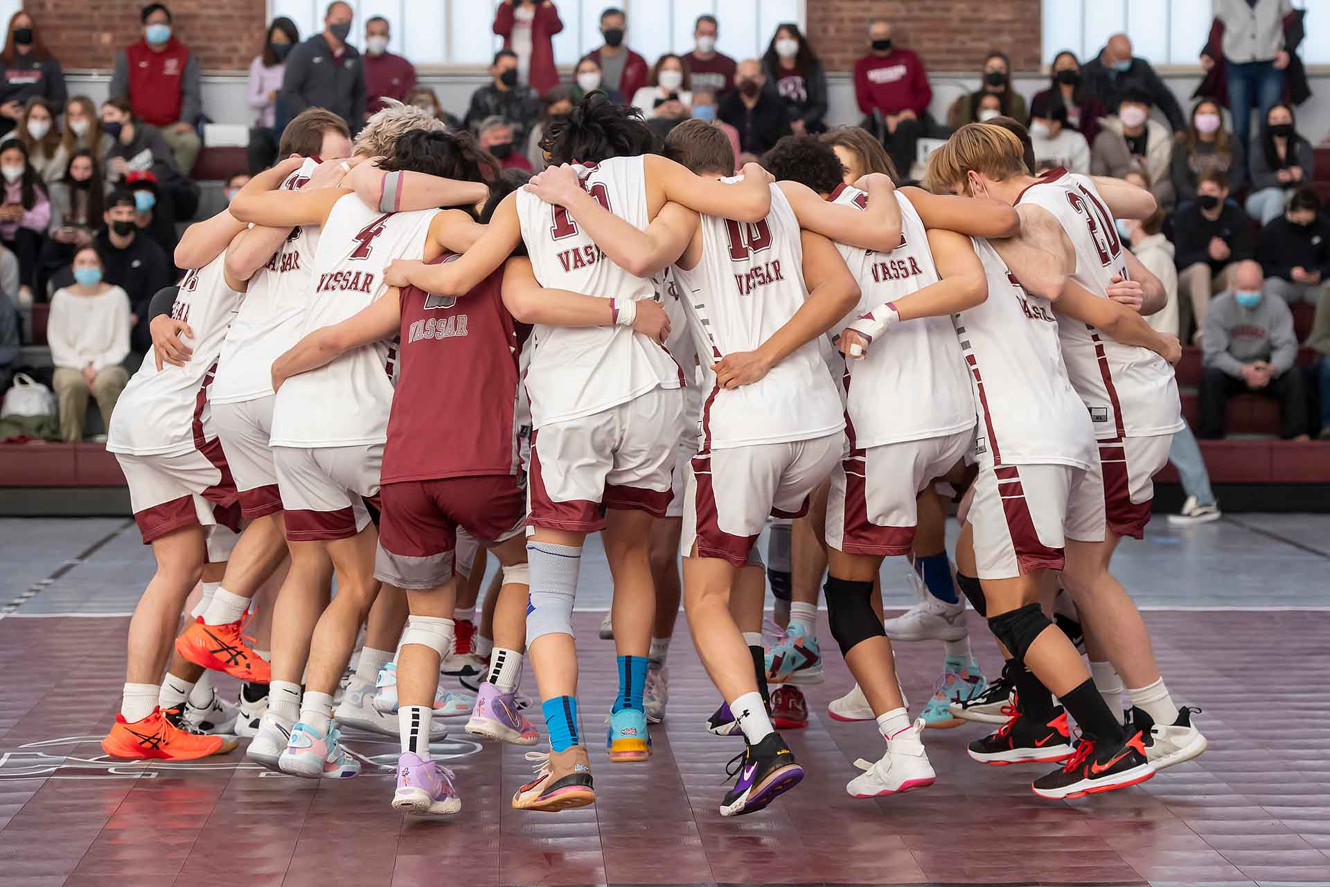 basketball team in a huddle jumping