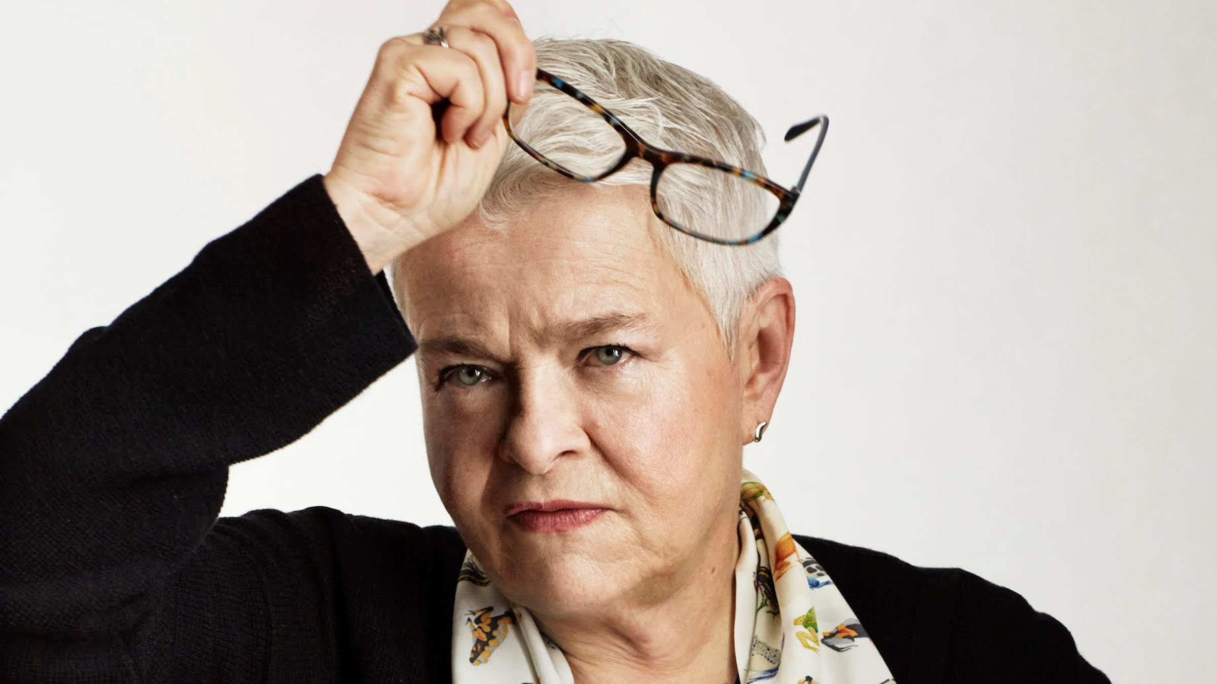 photo of a woman holding her glasses on her head