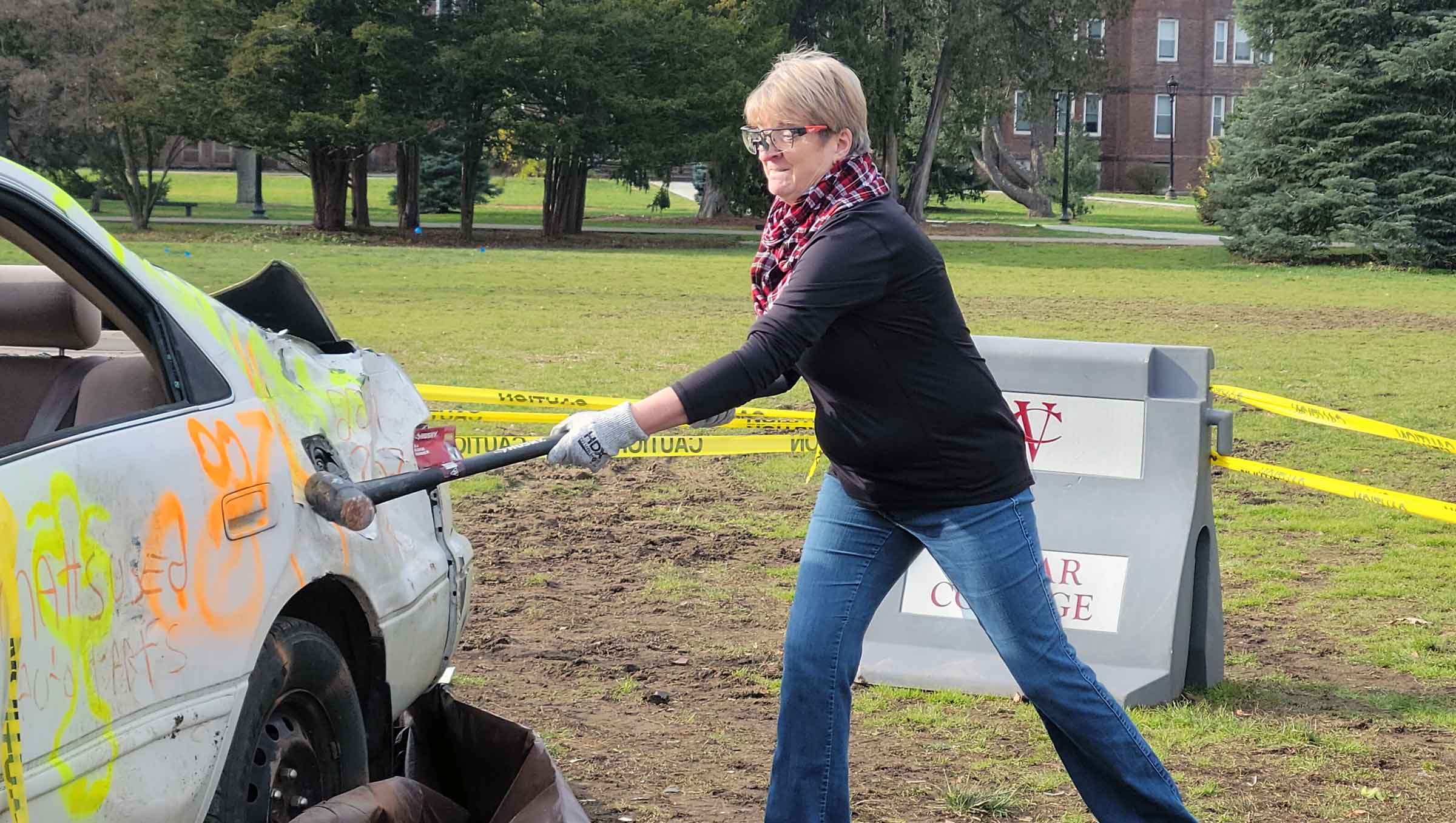 Person smashing a car with a sledge hammer