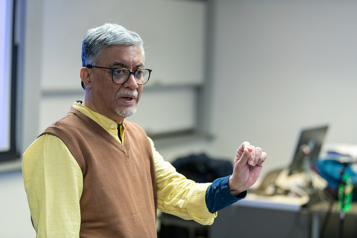 Dr. Anurag Mehra wearing a yellow shirt and brown sweater vest