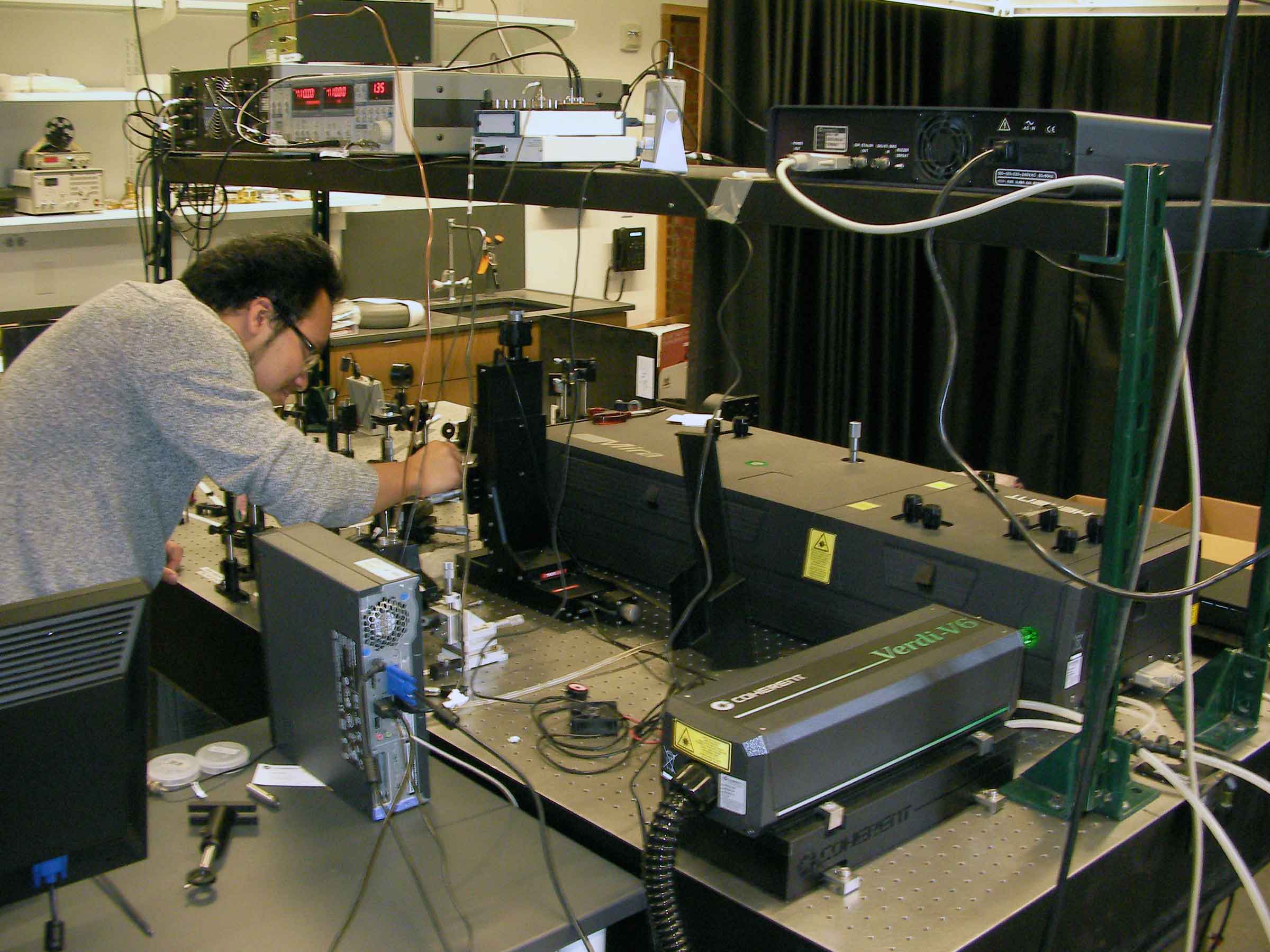 person at working on instruments in an Ultrafast Optics Laboratory