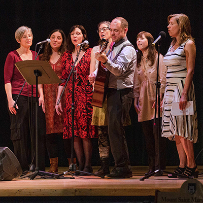 a group of people singing on a stage.