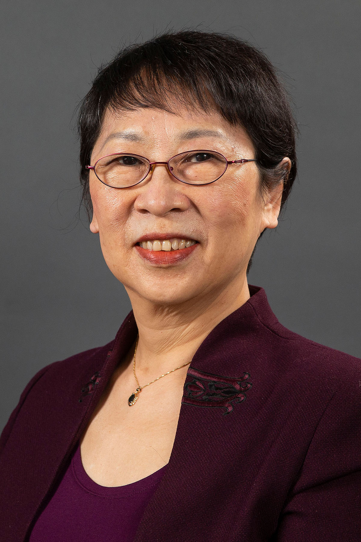 Peipei Qiu wearing a burgundy shirt and jacket