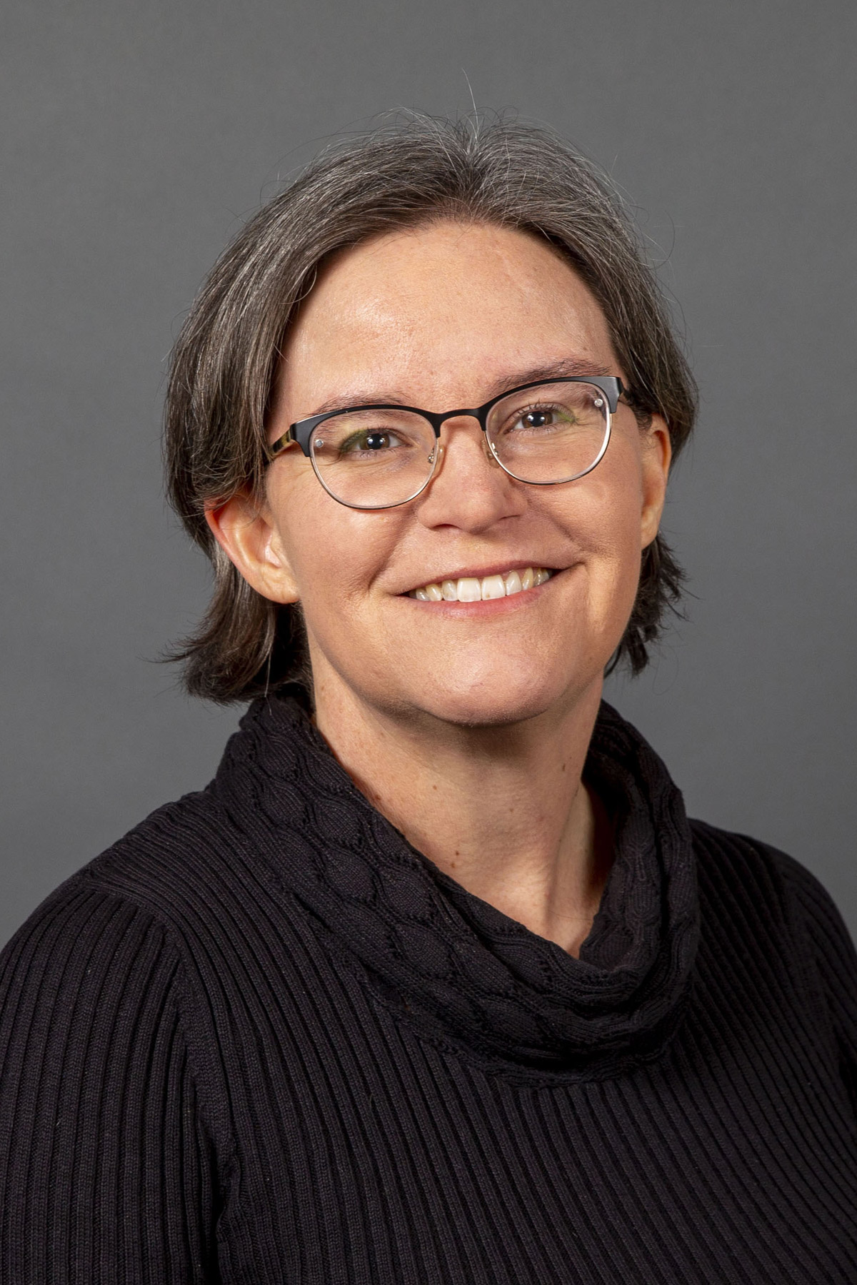 Woman in a black sweater smiling - Pictured: Jennifer Kennell