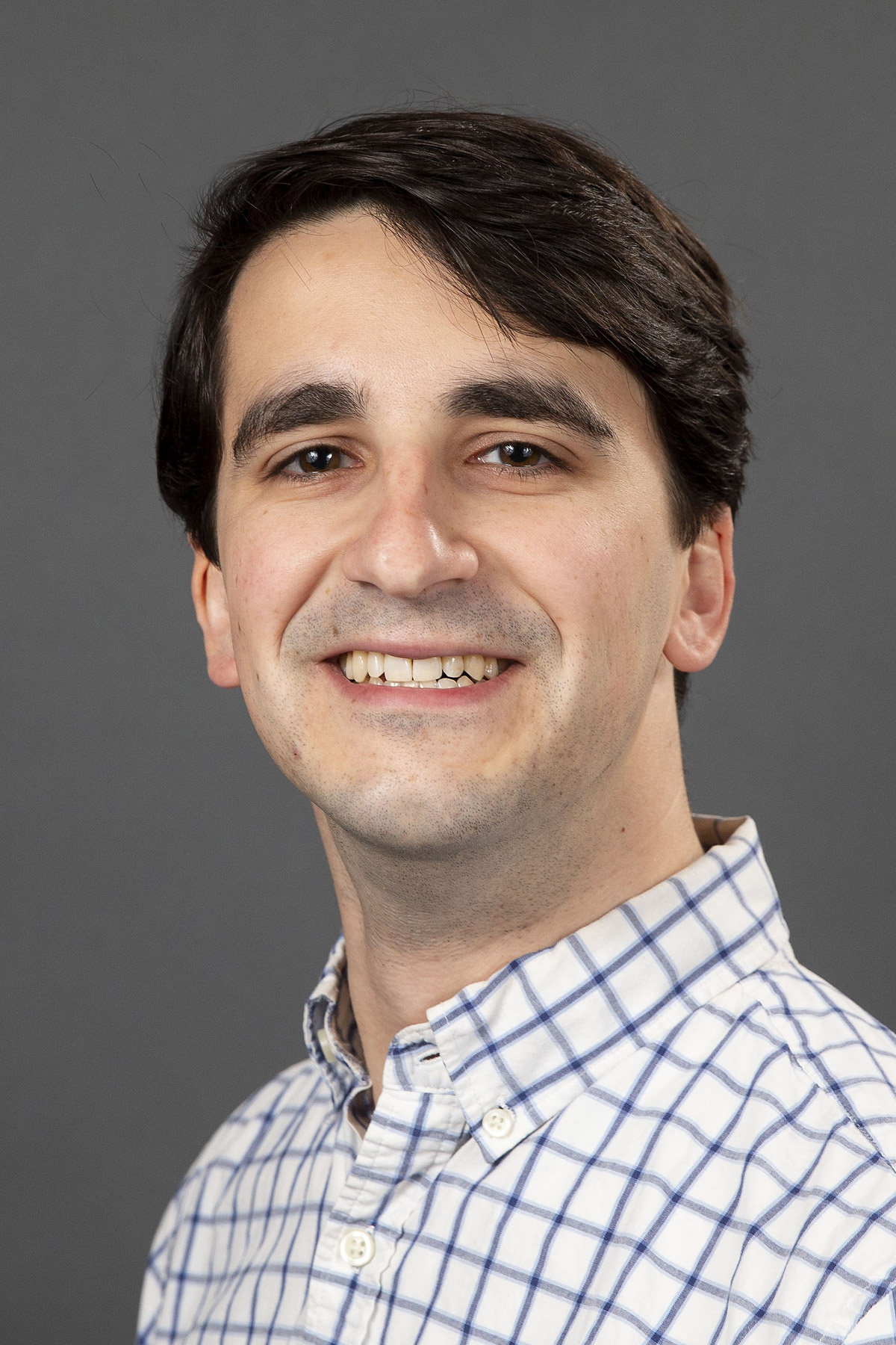 Man smiling in a striped collared shirt